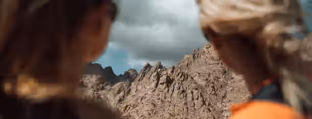 Ascending Peaks: The Path to Leadership Two individuals gaze at a rugged mountain peak, symbolizing the challenging yet rewarding journey of emerging leadership and self-improvement.