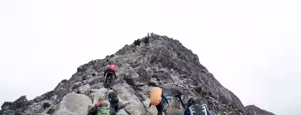 Climbing the Summit of Leadership: A Journey to Growth Climbers ascend a rugged, steep mountain path, symbolizing the determined and challenging journey of a leader's growth.