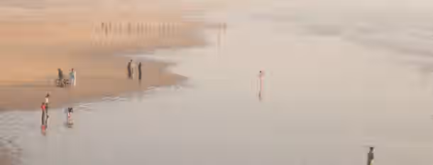 Steps to Leadership: A Journey on the Shore A lone figure stands at the water's edge, reflecting on a hazy horizon, amidst others along the shoreline, symbolizing self-improvement.