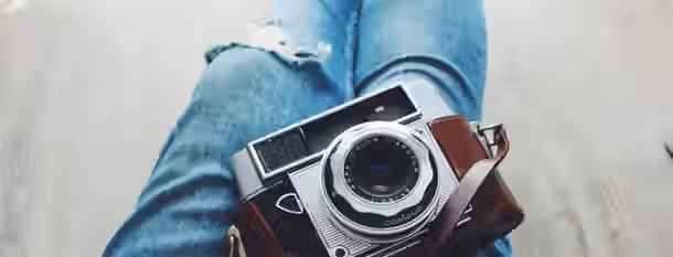 Focus on Growth: Journey to Leadership A vintage camera rests on ripped jeans, capturing the unfolding journey of an emerging leader striving for clarity and growth.